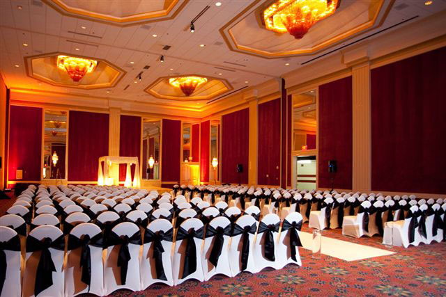black sashes on white spandex chair covers lined up for a wedding at a hotel