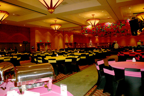 large conference room with black spandex chairs and neon yellow and pink sashes